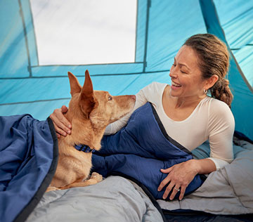 woman-and-dog-camping-in-tent-dog-sleeping-bag