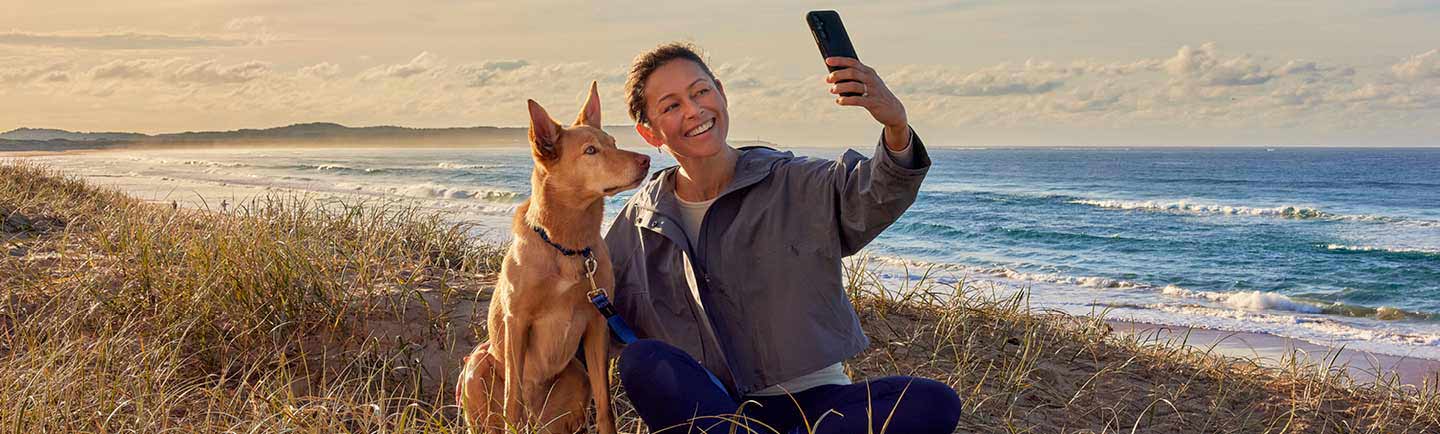 a-woman-taking-selfie-with-dog-on-a-beach-in-Australia