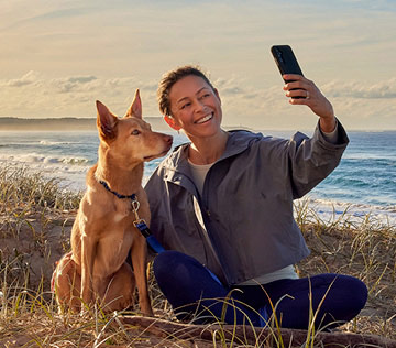 a-woman-taking-selfie-with-dog-on-a-beach-in-Australia
