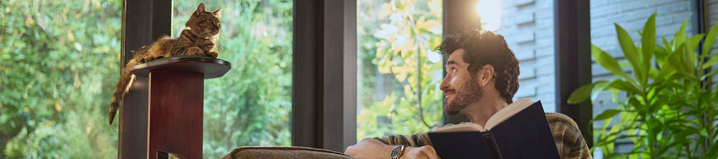 a-man-looking-at-his-cat-sitting-on-a-tower